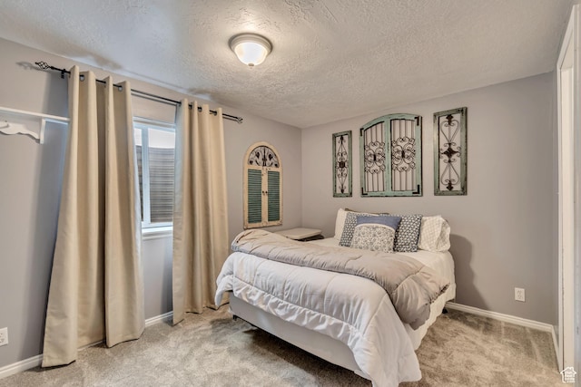bedroom featuring a textured ceiling, light colored carpet, and baseboards