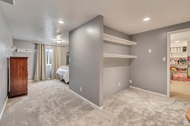 unfurnished bedroom featuring carpet flooring, recessed lighting, baseboards, and a spacious closet