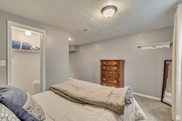 carpeted bedroom featuring a textured ceiling and baseboards