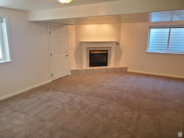 unfurnished living room featuring a fireplace, carpet, and baseboards