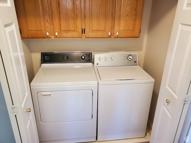 washroom featuring washer and dryer and cabinet space