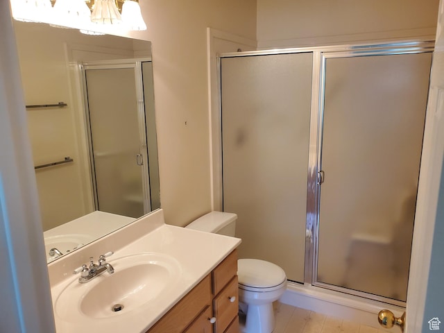 full bath featuring a chandelier, a stall shower, toilet, and vanity
