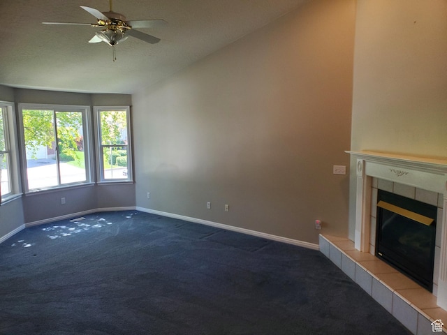 unfurnished living room featuring carpet flooring, baseboards, ceiling fan, a tile fireplace, and lofted ceiling
