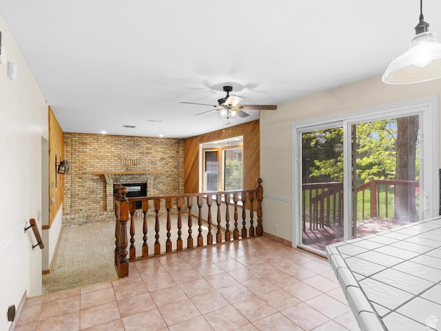 spare room featuring a ceiling fan, light tile patterned floors, a fireplace, and baseboards