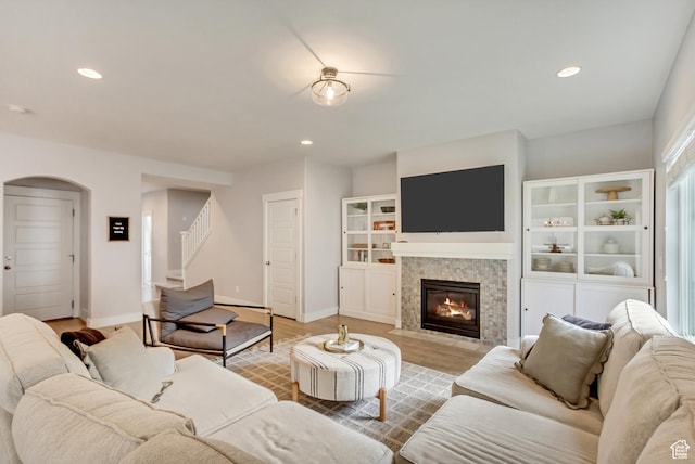 238 E Hillcrest Way N, Salt Lake, UT 84054 - living room with stairs, a fireplace, arched walkways, light wood-type flooring, and baseboards