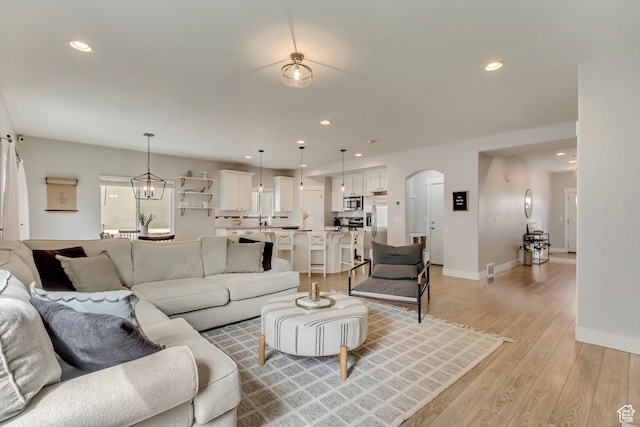 238 E Hillcrest Way N, Salt Lake, UT 84054 - living area featuring arched walkways, light wood-type flooring, baseboards, and recessed lighting