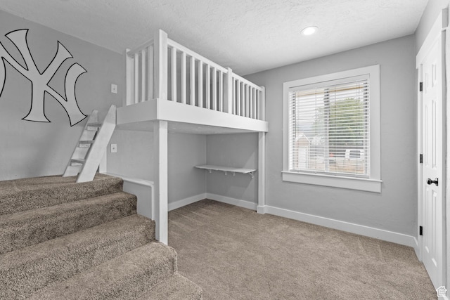 staircase with carpet, a textured ceiling, baseboards, and recessed lighting