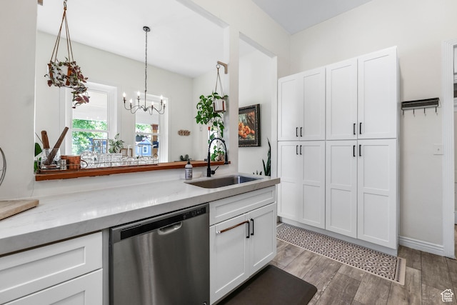 kitchen featuring stainless steel dishwasher, a sink, white cabinets, and light wood finished floors