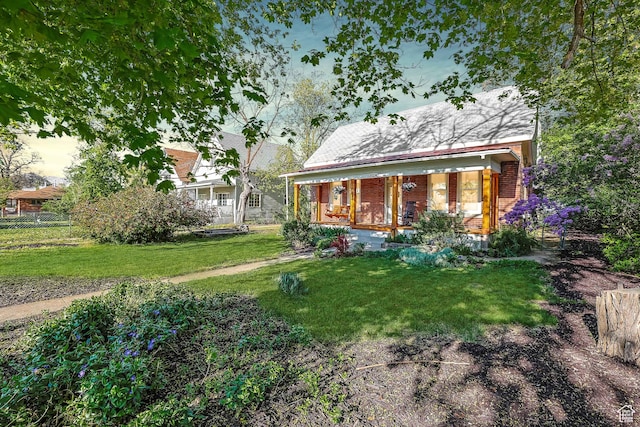 view of front of house featuring covered porch, brick siding, and a front lawn