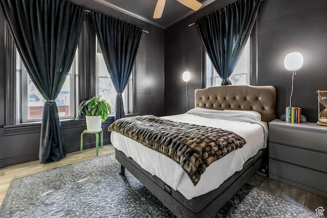 bedroom with crown molding, wood finished floors, and ceiling fan