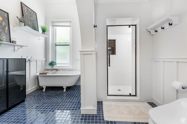 full bathroom featuring wainscoting, tile patterned floors, a shower stall, a decorative wall, and a freestanding bath