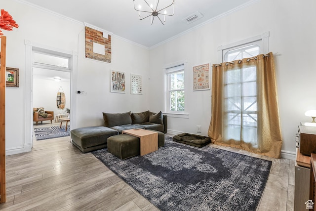 living area featuring a chandelier, ornamental molding, wood finished floors, and baseboards