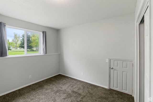 spare room with carpet floors, baseboards, and a textured ceiling