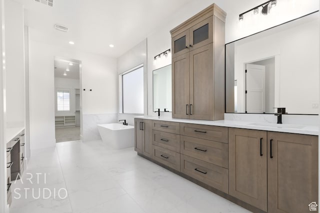 2832 E Stonedale Dr, St George, UT 84790 - full bath featuring a soaking tub, marble finish floors, double vanity, recessed lighting, and a wainscoted wall
