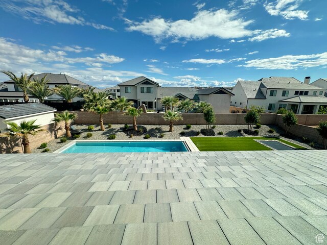 view of swimming pool featuring a residential view, a fenced backyard, and a patio area