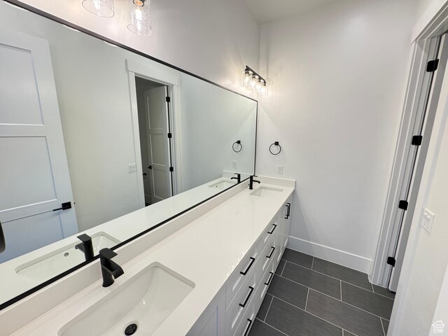 full bathroom with double vanity, tile patterned floors, and baseboards