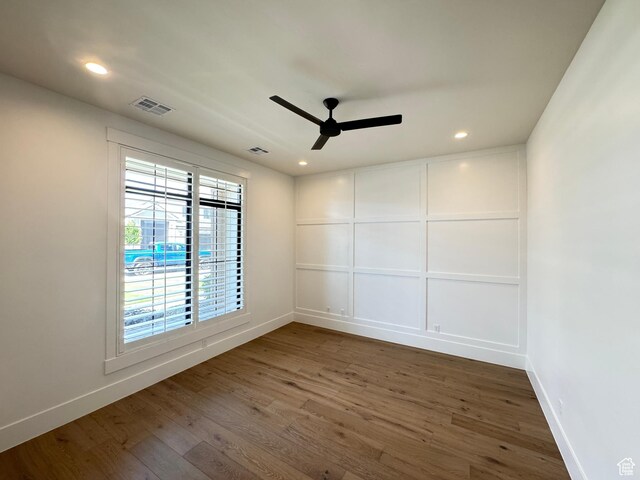 spare room with a ceiling fan, baseboards, wood finished floors, and recessed lighting