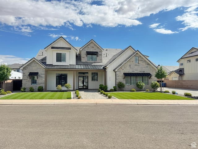 view of front of home with a standing seam roof, board and batten siding, stone siding, and metal roof
