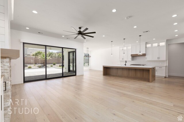 2832 E Stonedale Dr, St George, UT 84790 - unfurnished living room with ceiling fan, recessed lighting, baseboards, light wood finished floors, and a stone fireplace