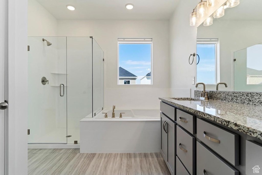 bathroom featuring a shower stall, a bath, vanity, and wood finished floors