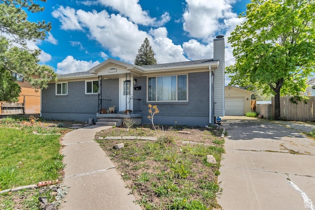 172 E 400 N, Tooele, UT 84074 - view of front of property featuring fence, a chimney, brick siding, a detached garage, and concrete driveway