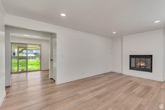172 E 400 N, Tooele, UT 84074 - unfurnished living room featuring ornamental molding, recessed lighting, baseboards, a warm lit fireplace, and light wood finished floors