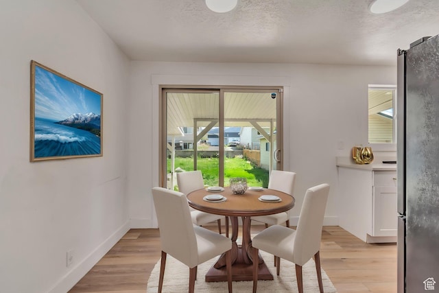 172 E 400 N, Tooele, UT 84074 - dining room featuring light wood-style floors, baseboards, and a textured ceiling