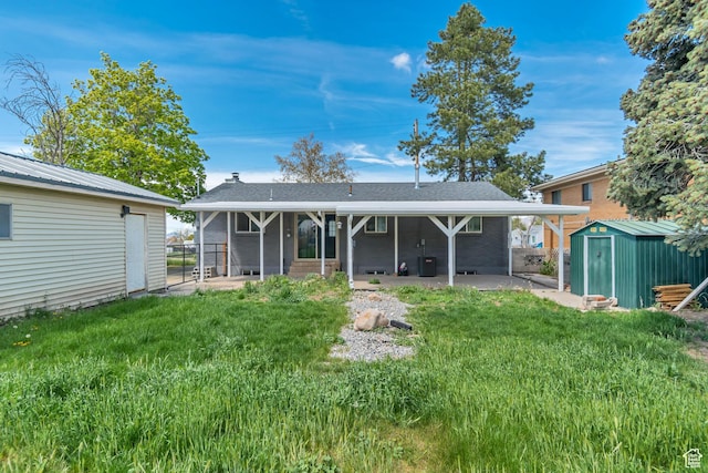 172 E 400 N, Tooele, UT 84074 - back of property featuring a patio area, a storage unit, an outbuilding, and a yard