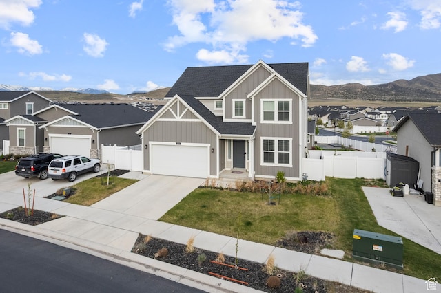 view of front of property featuring board and batten siding, concrete driveway, a residential view, a shingled roof, and a mountain view