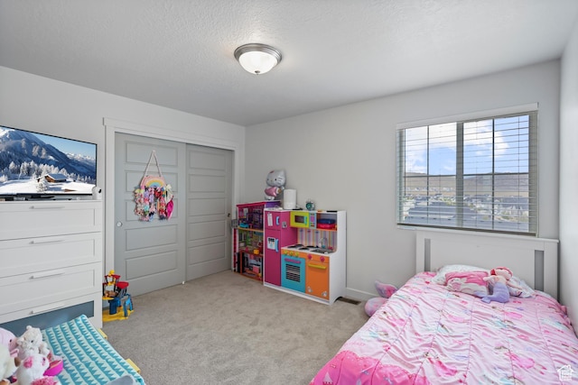 carpeted bedroom featuring a textured ceiling and a closet
