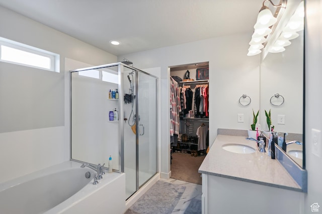bathroom with a shower stall, a bath, vanity, a walk in closet, and recessed lighting
