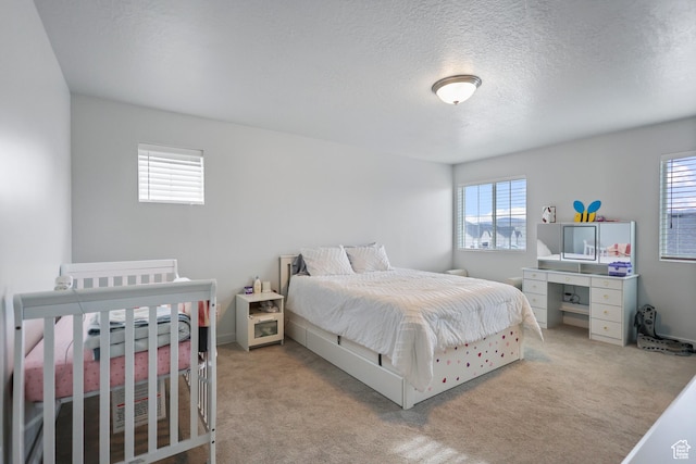 carpeted bedroom with multiple windows and a textured ceiling