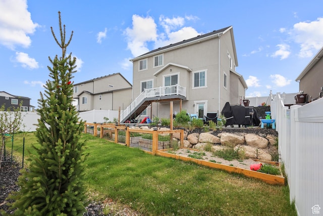 rear view of house with stucco siding and stairway