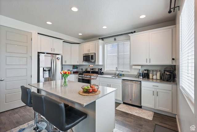 kitchen with stainless steel appliances, white cabinetry, dark wood-style flooring, and recessed lighting