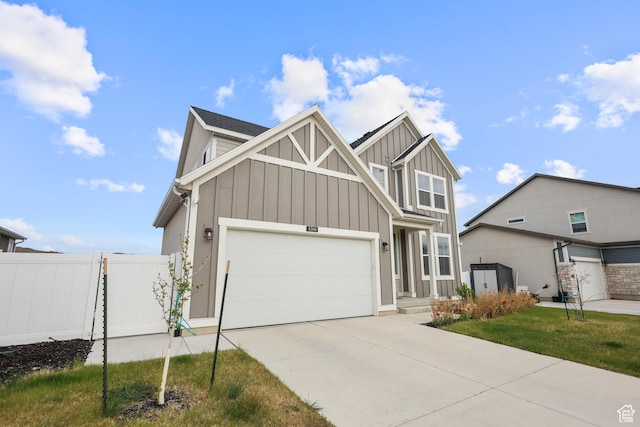 craftsman-style home with board and batten siding, fence, driveway, and a garage