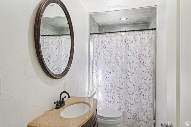 bathroom with toilet, vanity, and a shower with curtain