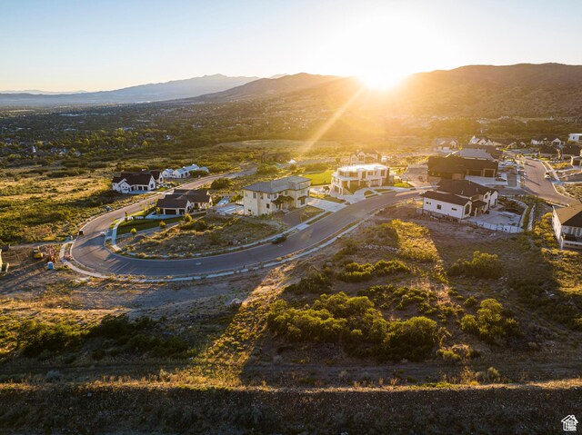 aerial view of property's location with a mountainous background and nearby suburban area