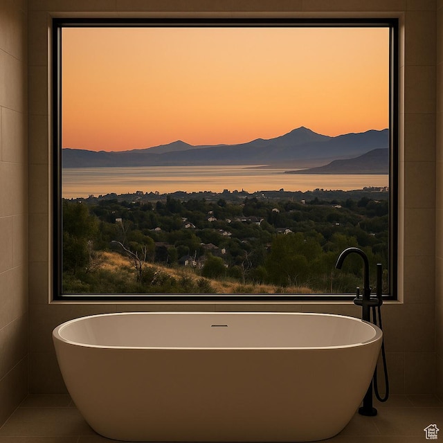 bathroom with a mountain view, tile patterned flooring, and a freestanding tub