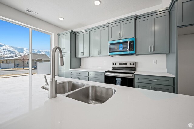 621 S 85 E Unit 24, Smithfield, UT 84335 - kitchen featuring appliances with stainless steel finishes, a sink, a mountain view, light countertops, and recessed lighting