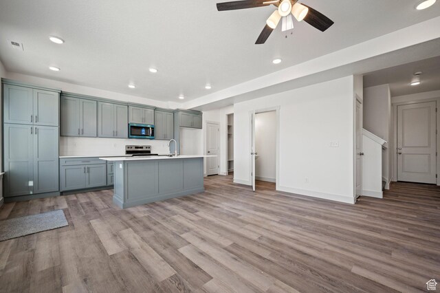 621 S 85 E Unit 24, Smithfield, UT 84335 - kitchen with appliances with stainless steel finishes, light countertops, light wood-style floors, recessed lighting, and a kitchen island with sink