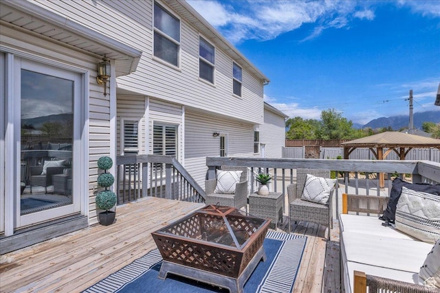 deck featuring a fire pit, a gazebo, and fence