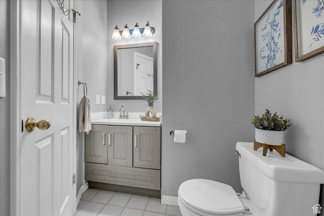bathroom featuring toilet, tile patterned floors, vanity, and baseboards