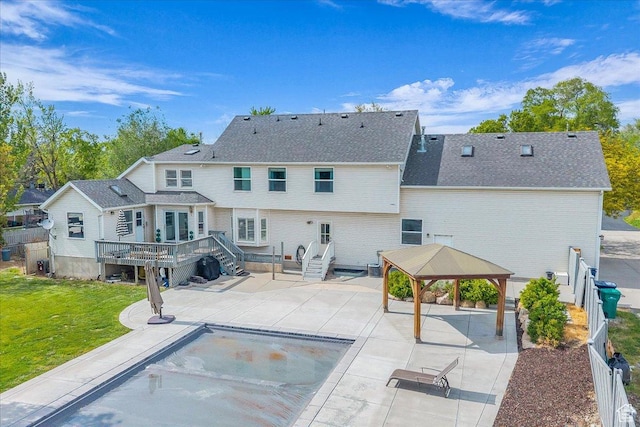 rear view of property featuring a gazebo, a patio, a deck, and an outdoor pool