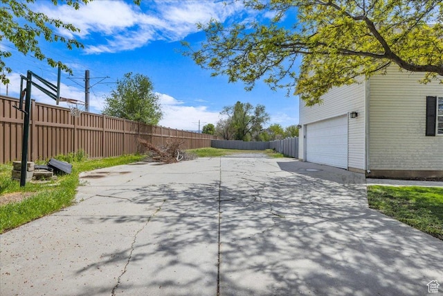 view of yard featuring fence and driveway