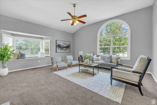 carpeted living area featuring a ceiling fan, lofted ceiling, and baseboards