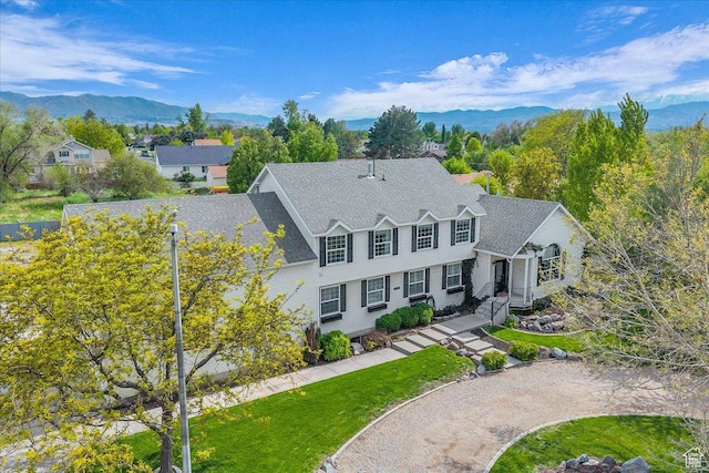 view of front of home with a front yard and a mountain view