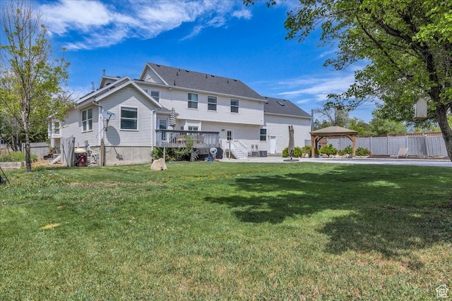rear view of house with a gazebo, a wooden deck, and a patio area