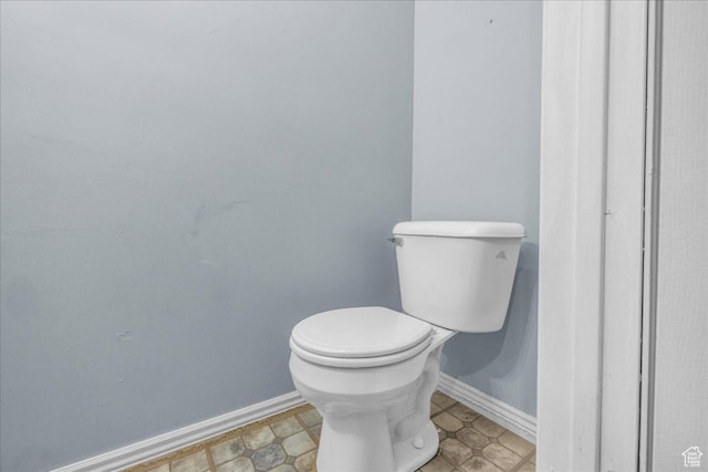 bathroom with baseboards and toilet