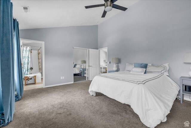 carpeted bedroom featuring baseboards, high vaulted ceiling, a ceiling fan, and ensuite bath