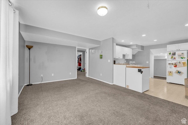 unfurnished living room with light carpet, baseboards, and recessed lighting